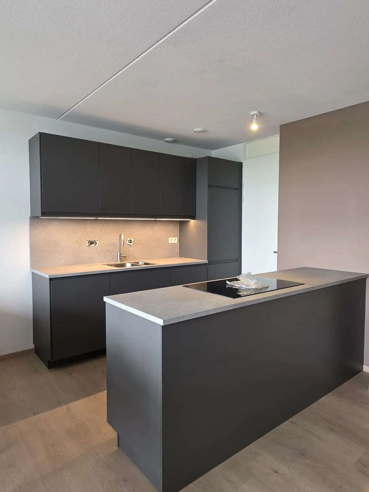 Moderne keuken met kookeiland, strak afgewerkt na renovatie